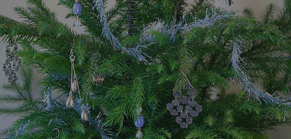 Closeup of Norfolk Island Pine holiday season houseplant with tinsel and silver decorations