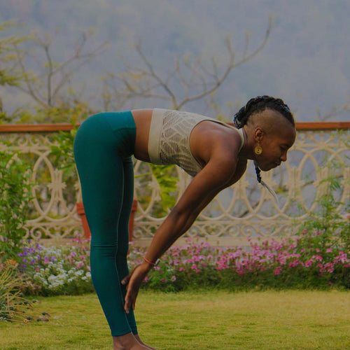 Woman doing Yoga in a garden with white Petunia, Pink Dianthus, Orange Snapdragon, and other garden flowers