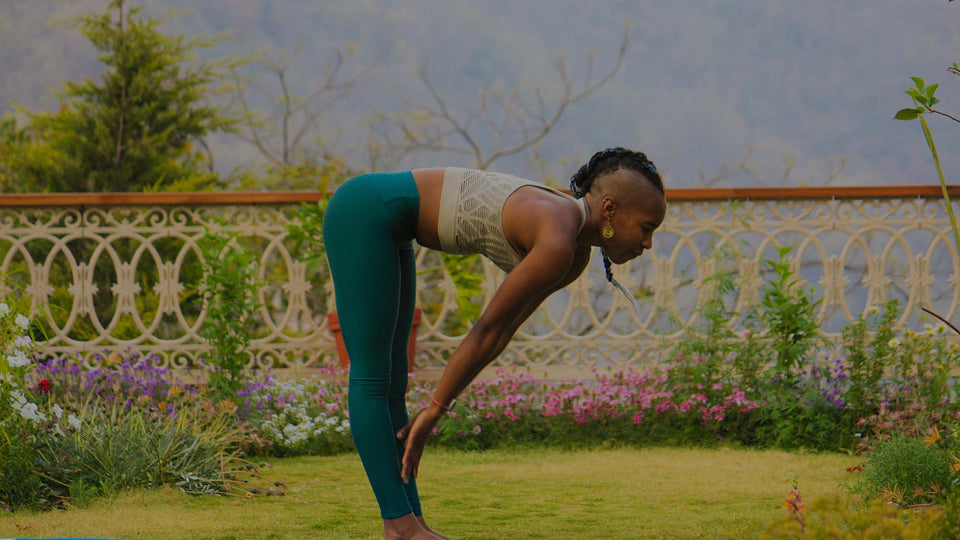 Woman doing Yoga in a garden with white Petunia, Pink Dianthus, Orange Snapdragon, and other garden flowers